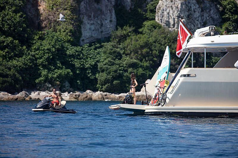 a couple of people on a boat with a flag on the front aboard BEST OFF Yacht for Charter