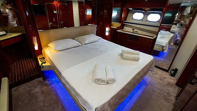 a room with a bed and a mirror aboard BONA DEA Yacht for Sale