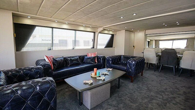 a living room with leather couches and a table aboard BONA DEA Yacht for Sale