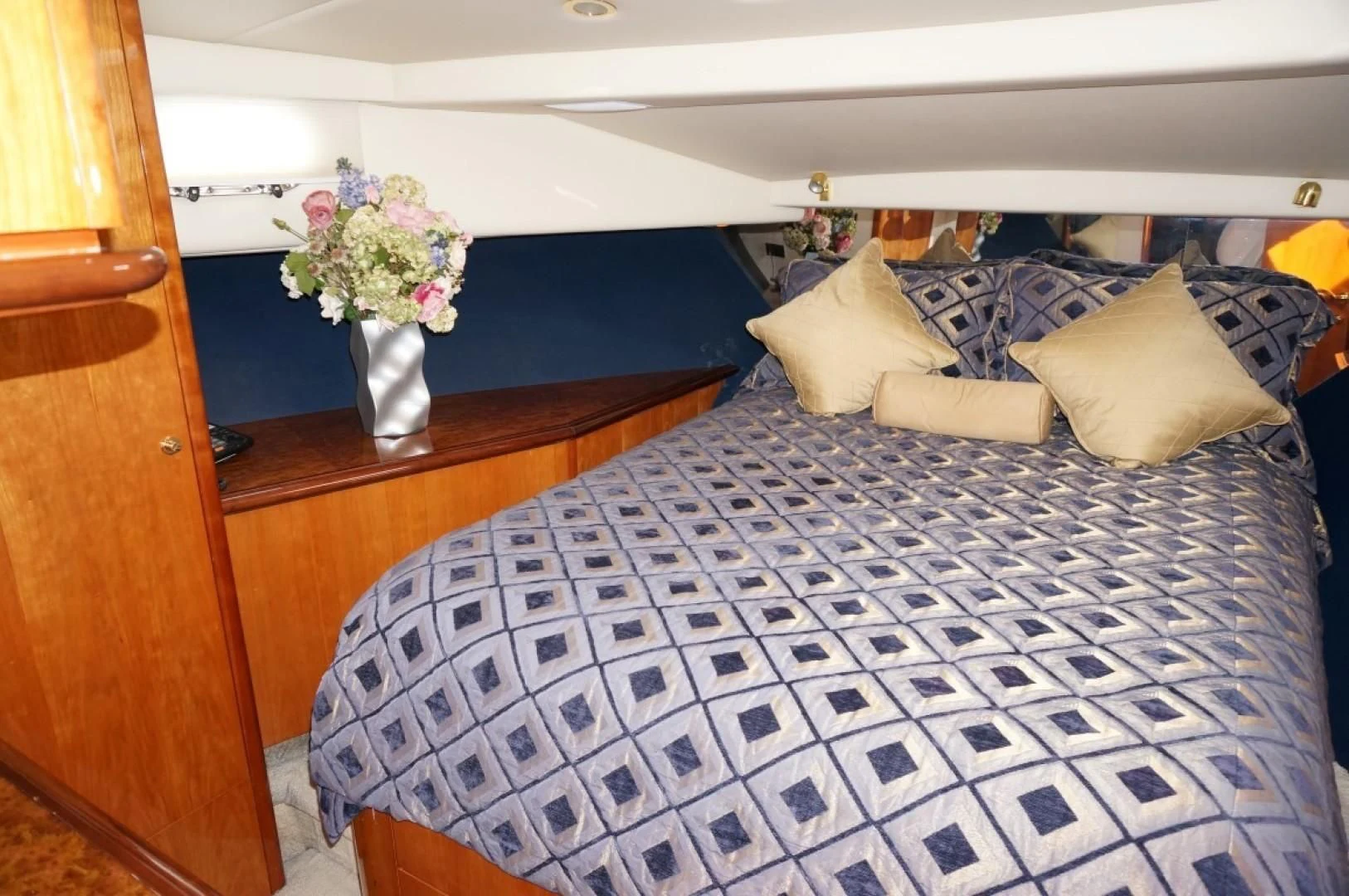 a bed with blue and white sheets aboard SWEET LADY Yacht for Sale