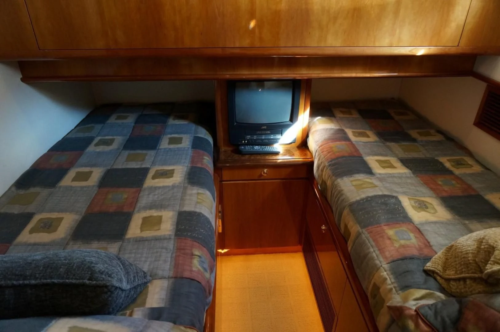 a bed with a plaid bedspread and a television on it aboard SWEET LADY Yacht for Sale