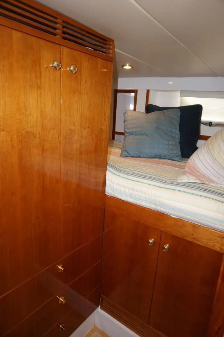 a bedroom with a wood cabinet aboard SWEET LADY Yacht for Sale