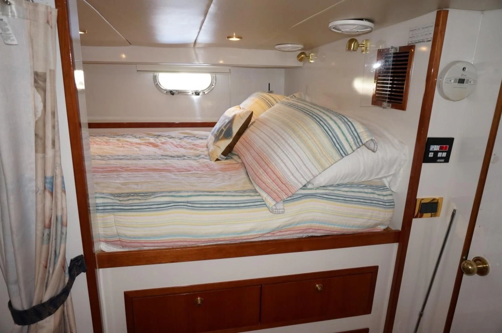 a bed with a striped pillow aboard SWEET LADY Yacht for Sale