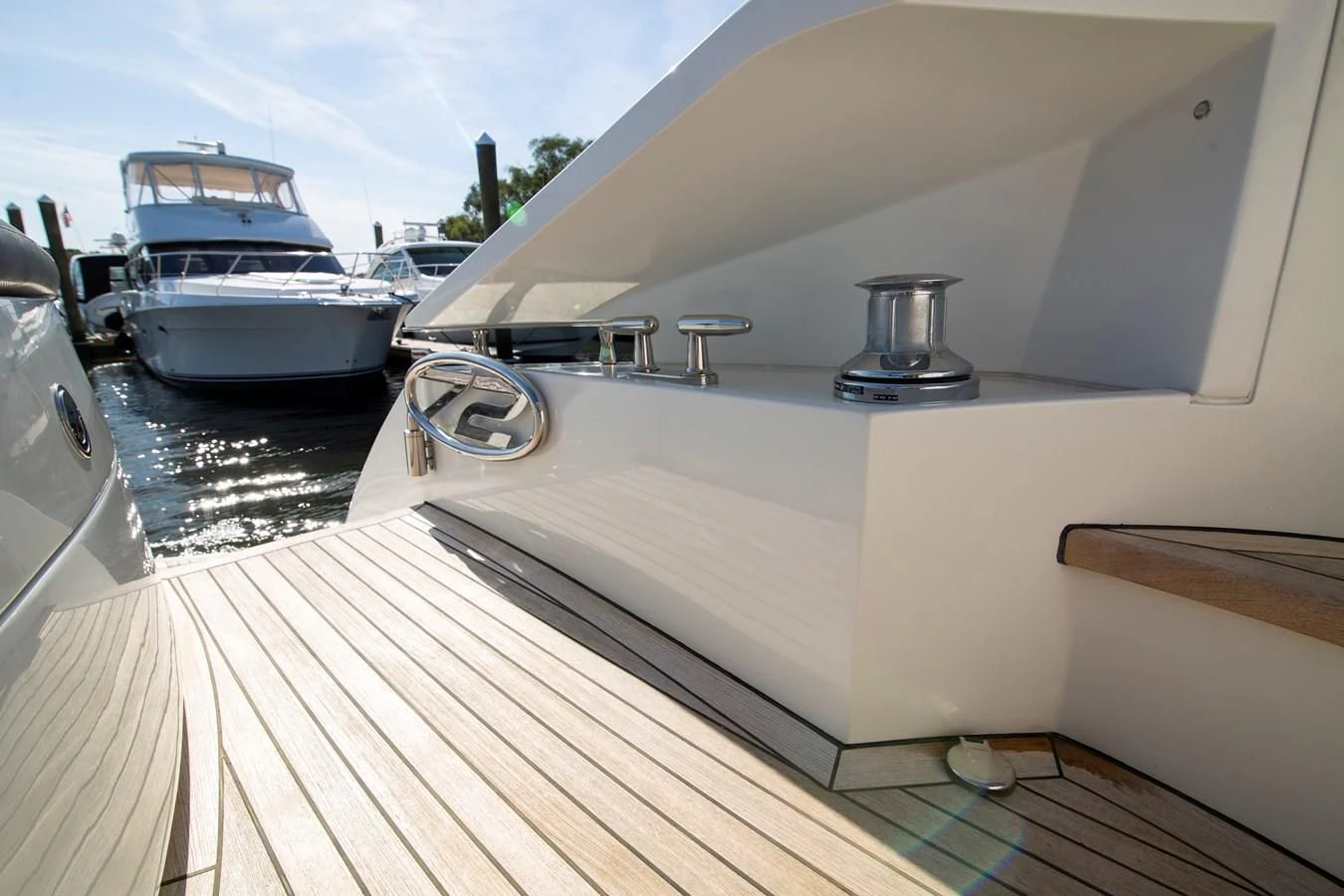 a deck with a boat and a large yacht in the background aboard UPTOWN GIRL Yacht for Sale