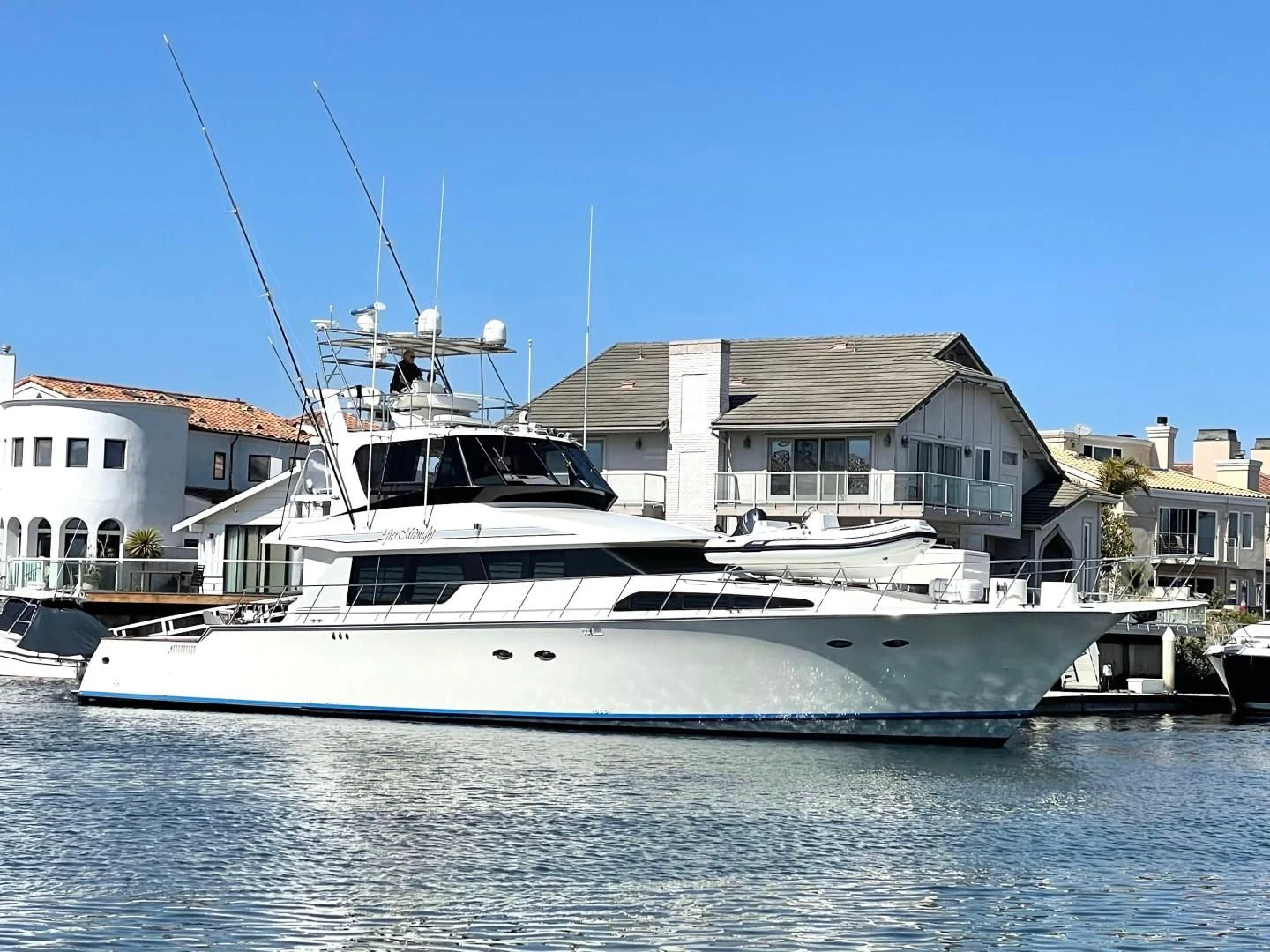 a white boat in a harbor aboard AFTER MIDNIGHT Yacht for Sale