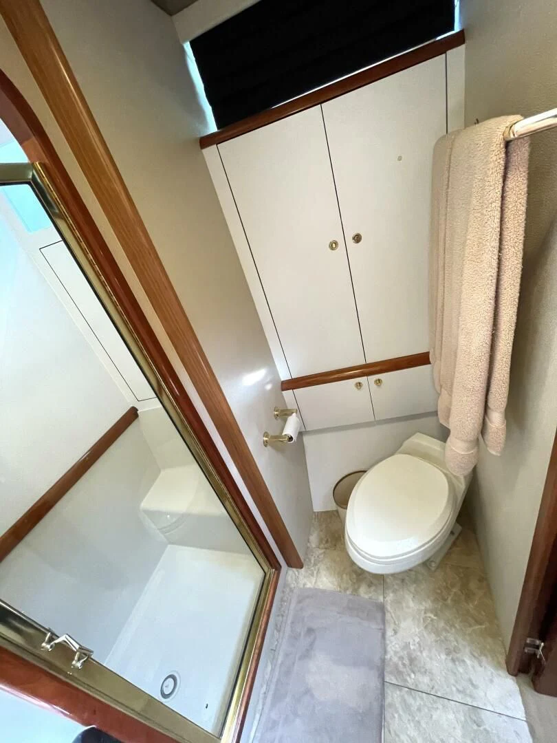 a bathroom with a toilet and a mirror aboard AFTER MIDNIGHT Yacht for Sale