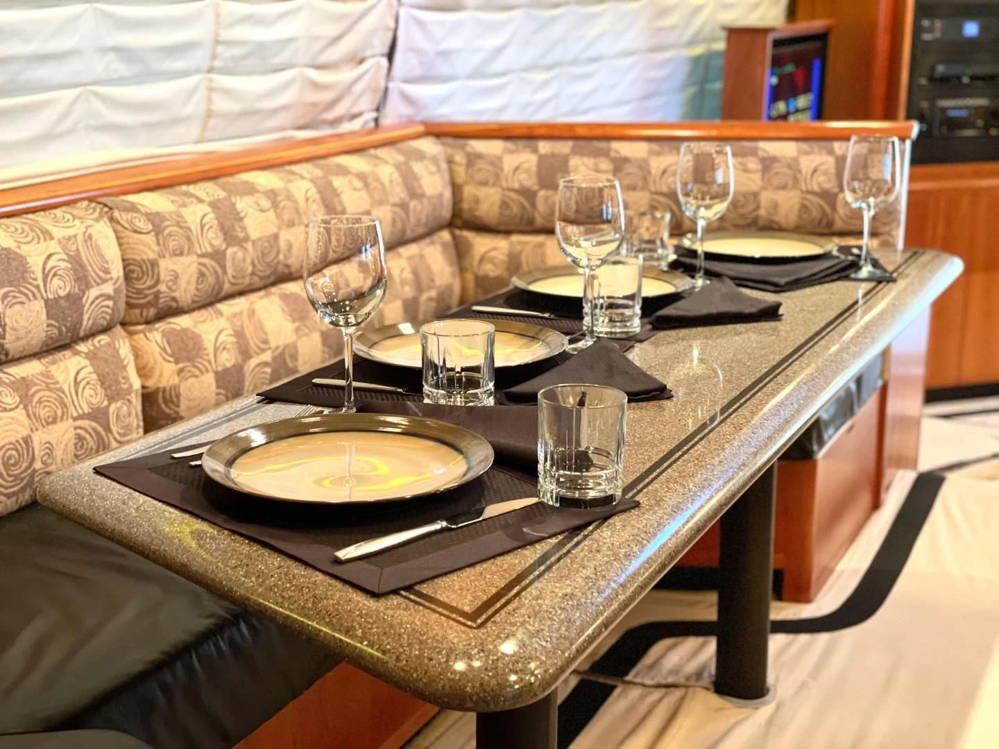 a table with wine glasses and plates on it aboard AFTER MIDNIGHT Yacht for Sale