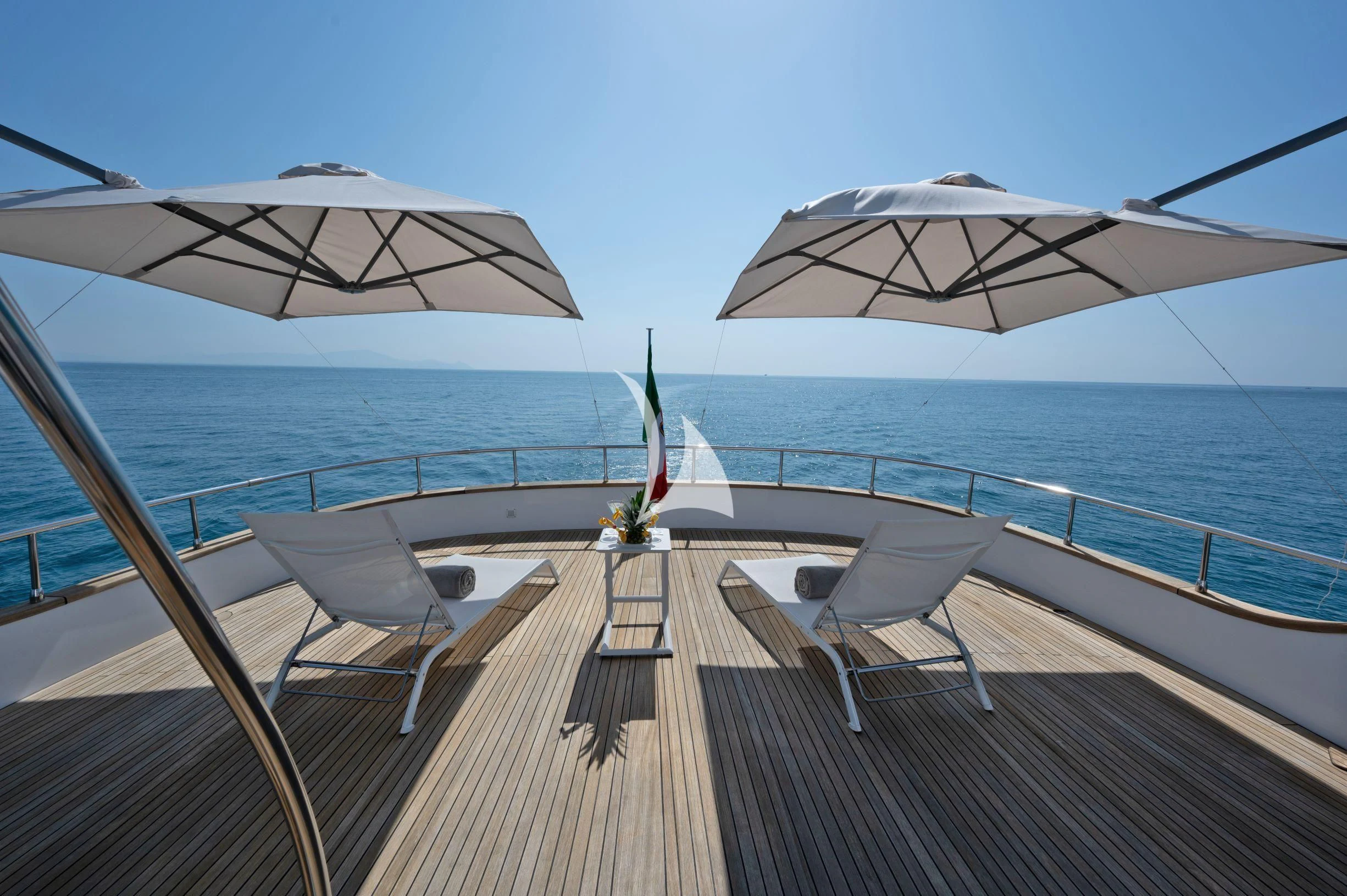 a deck with chairs and umbrellas on it aboard TANANAI Yacht for Sale