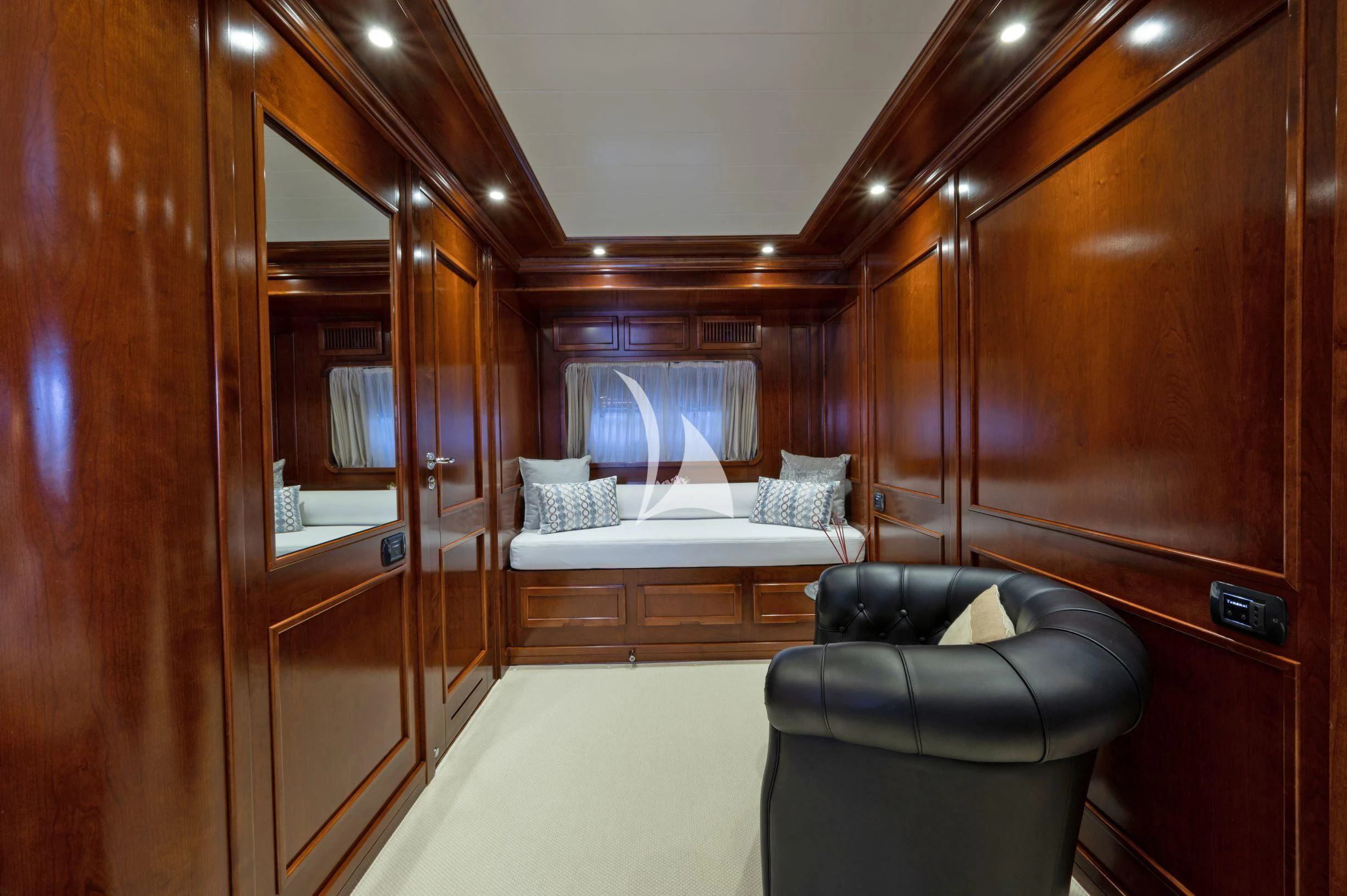 a room with a bed and a chair aboard TANANAI Yacht for Sale