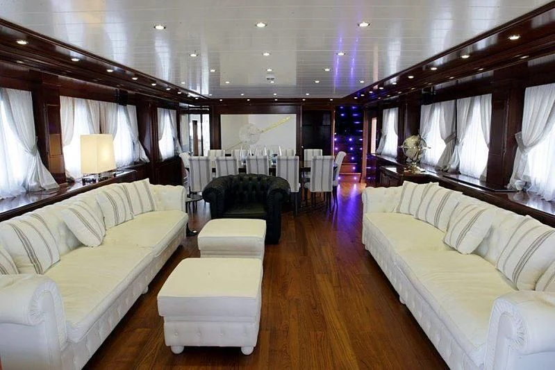 a room with a bed and a couch aboard TANANAI Yacht for Sale