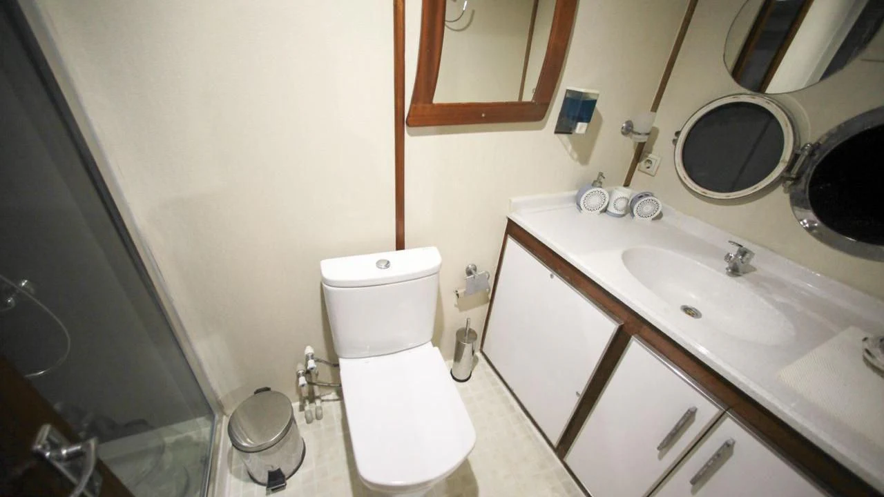 a bathroom with a toilet sink and a mirror aboard WHITE SWAN Yacht for Sale