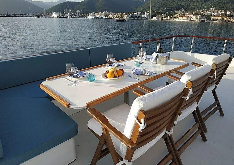 a table with chairs and a view of a city aboard WHITE SWAN Yacht for Sale