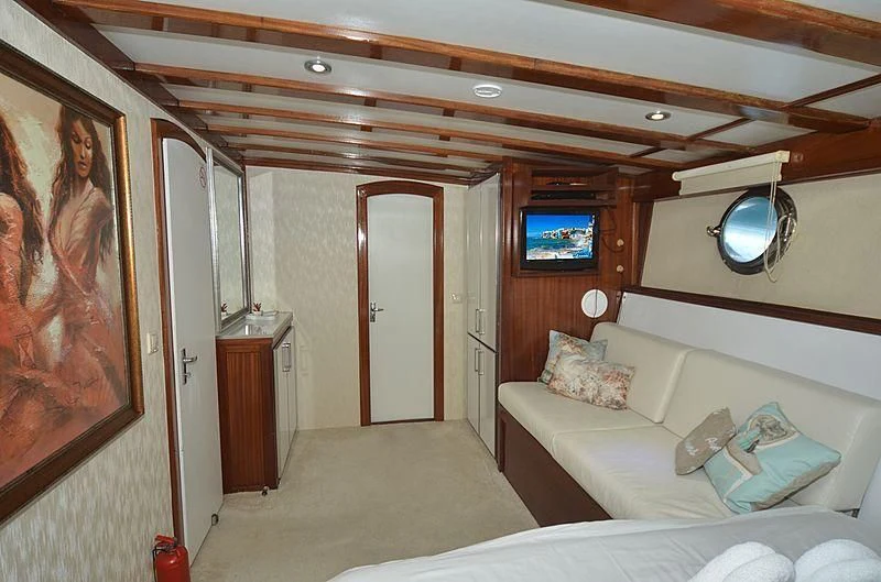 a room with a bed and a mirror aboard WHITE SWAN Yacht for Sale