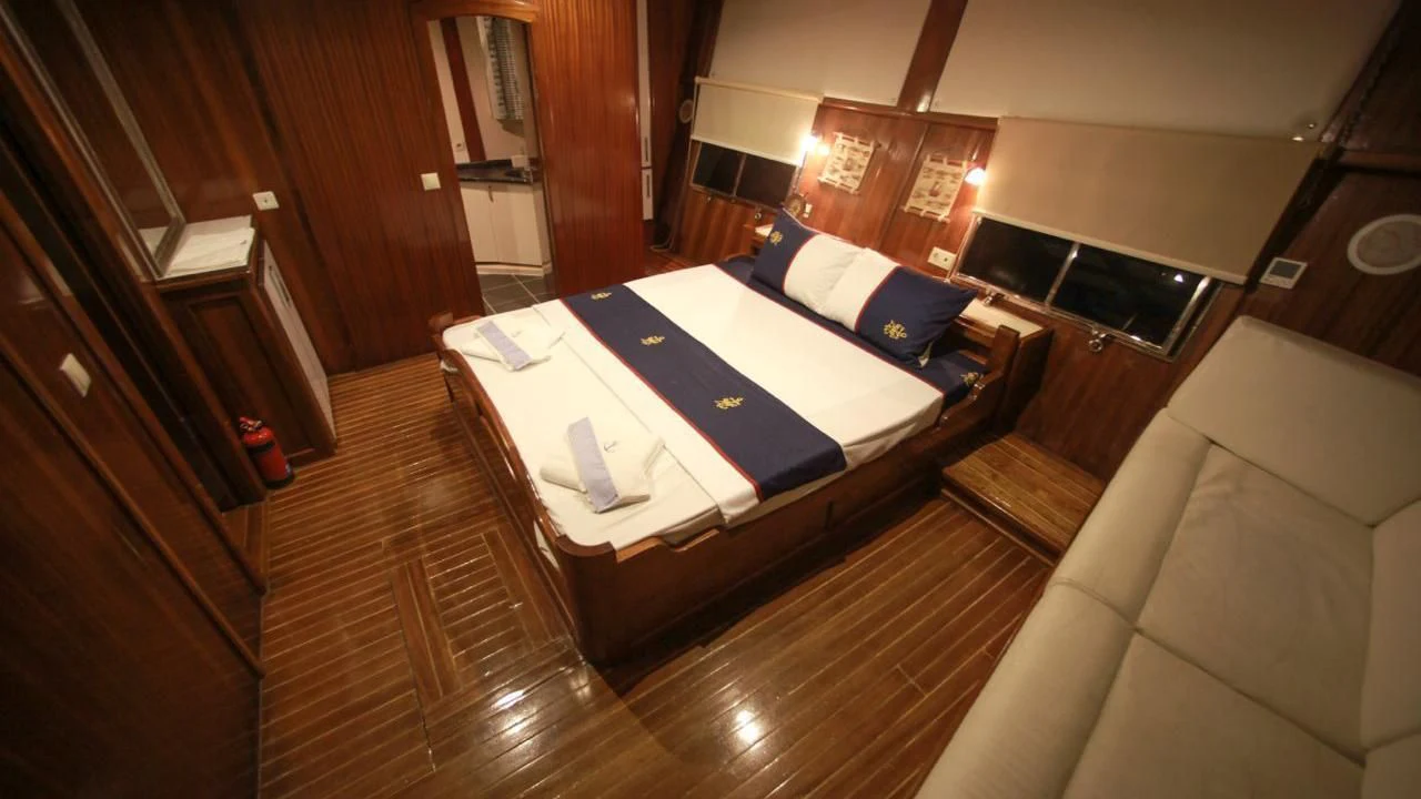 a hotel room with a bed and a table aboard WHITE SWAN Yacht for Sale
