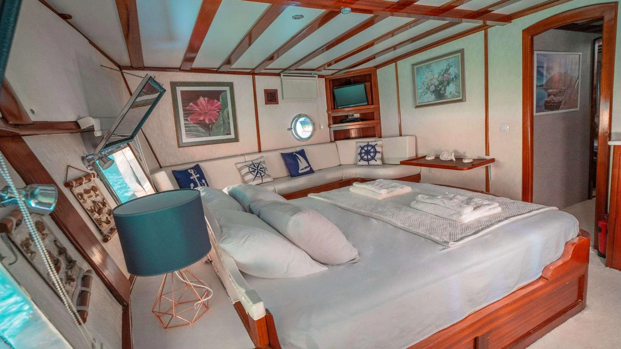 a bedroom with a bed and a table aboard WHITE SWAN Yacht for Sale