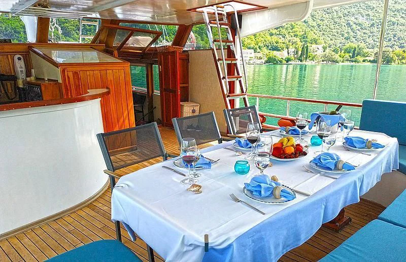 a table with plates and glasses on it aboard WHITE SWAN Yacht for Sale