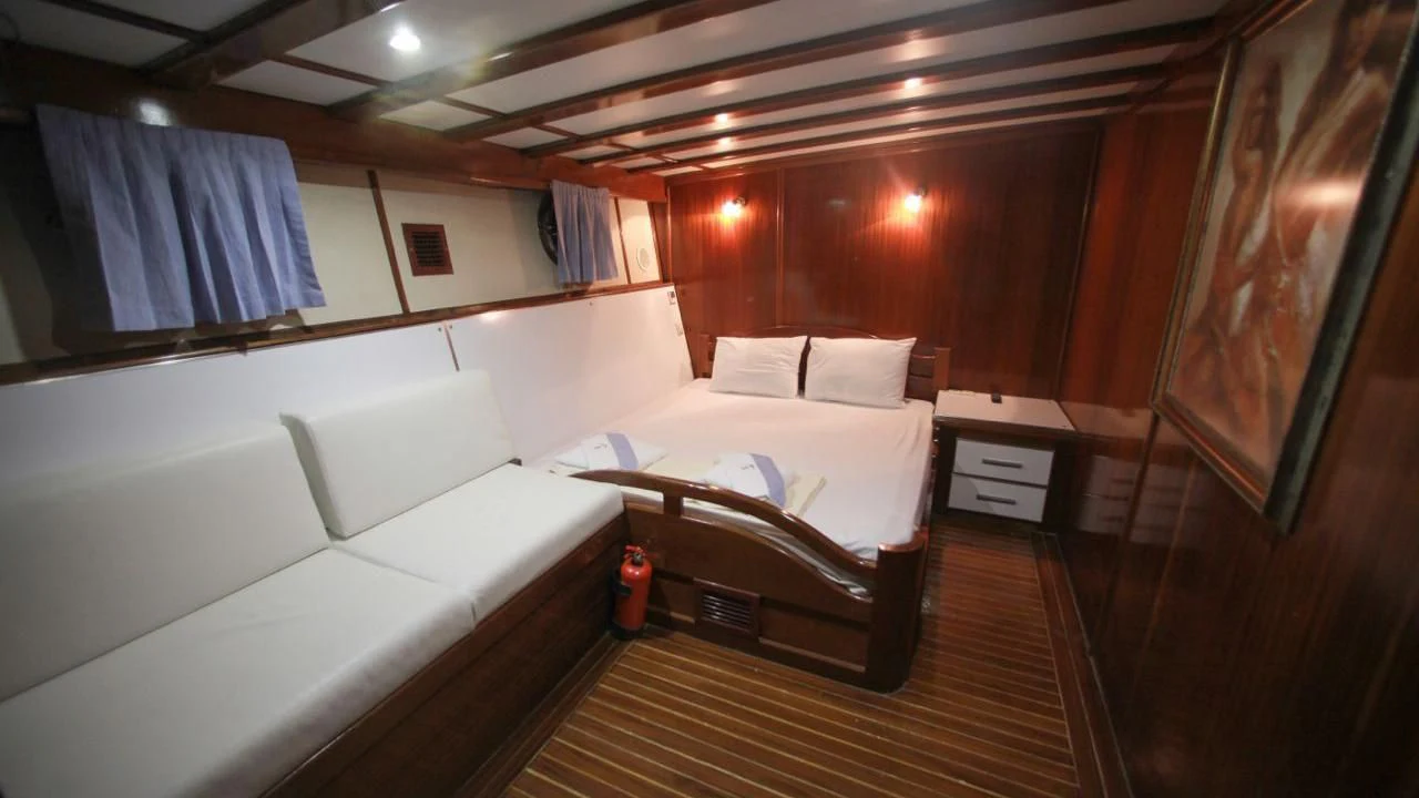 a room with a bed and a couch aboard WHITE SWAN Yacht for Sale