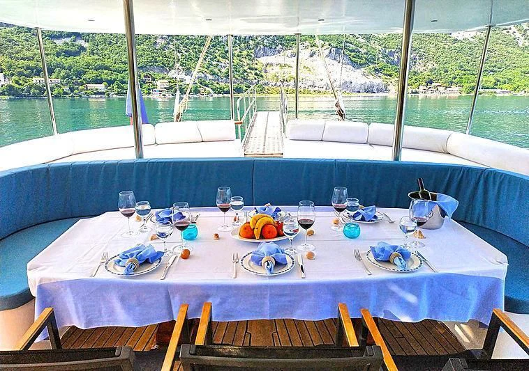 a table with plates and glasses on it aboard WHITE SWAN Yacht for Sale