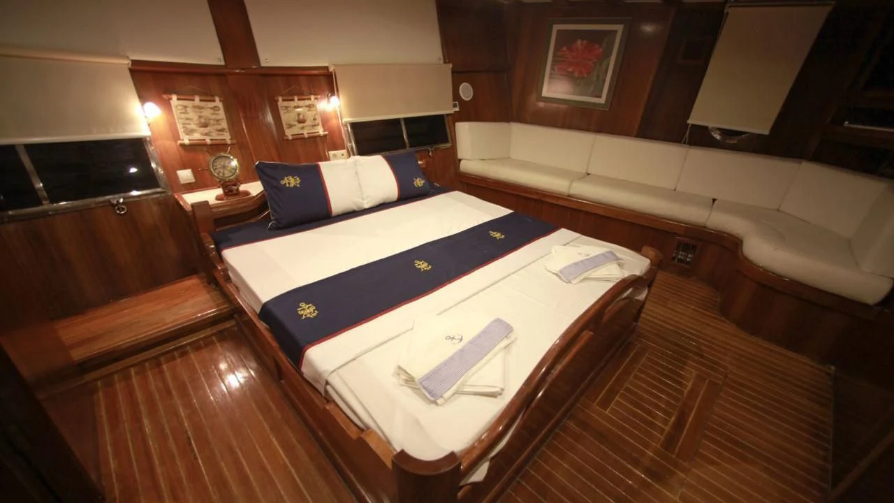 a room with a bed and a table aboard WHITE SWAN Yacht for Sale