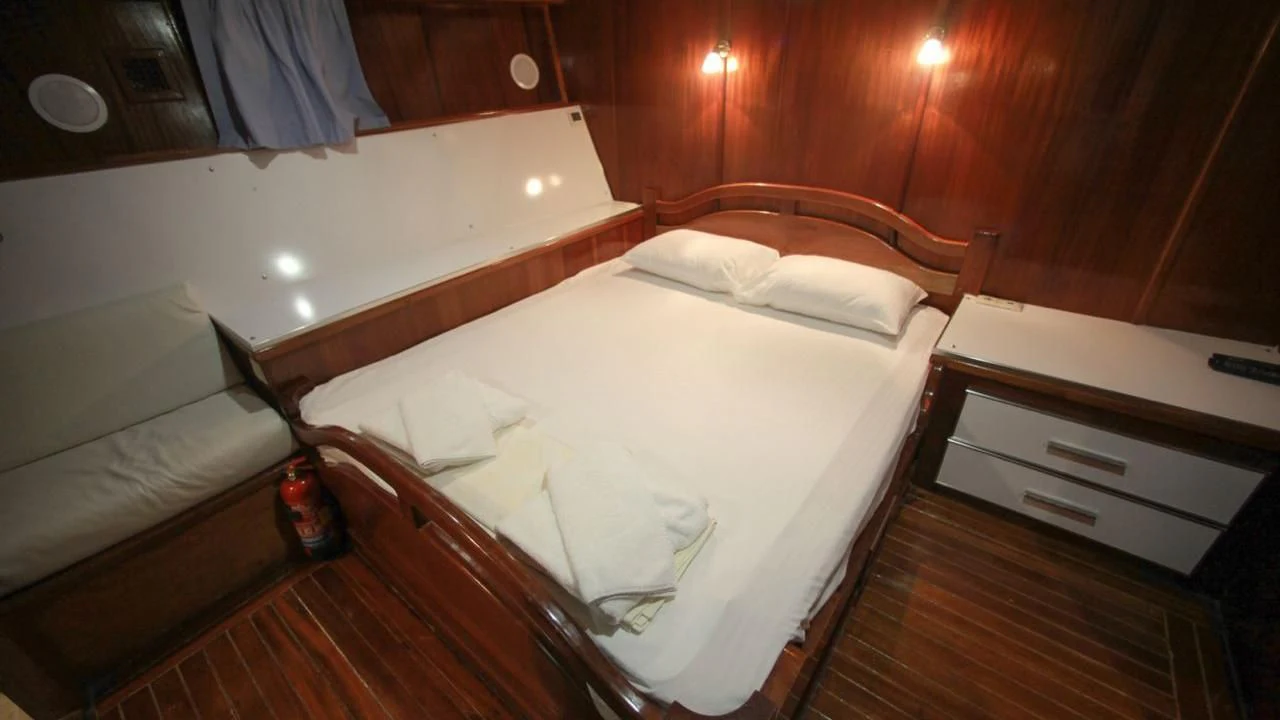 a room with a bed and a dresser aboard WHITE SWAN Yacht for Sale