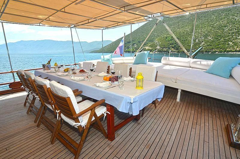 a table set for a meal on a deck overlooking a body of water aboard WHITE SWAN Yacht for Sale