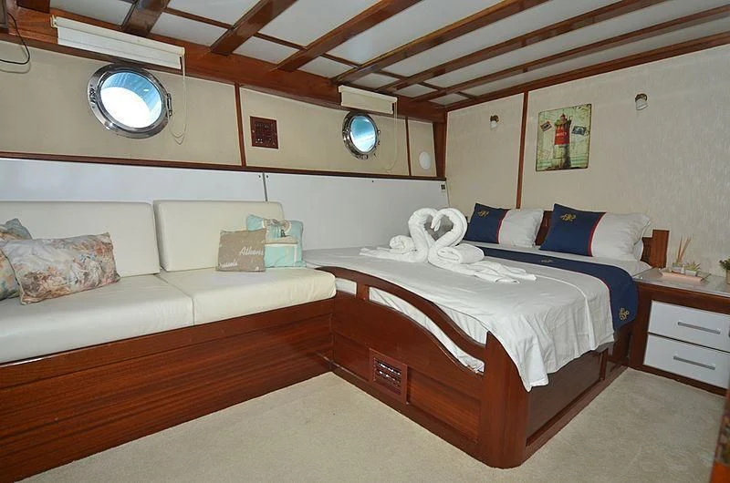 a room with a bed and a couch aboard WHITE SWAN Yacht for Sale