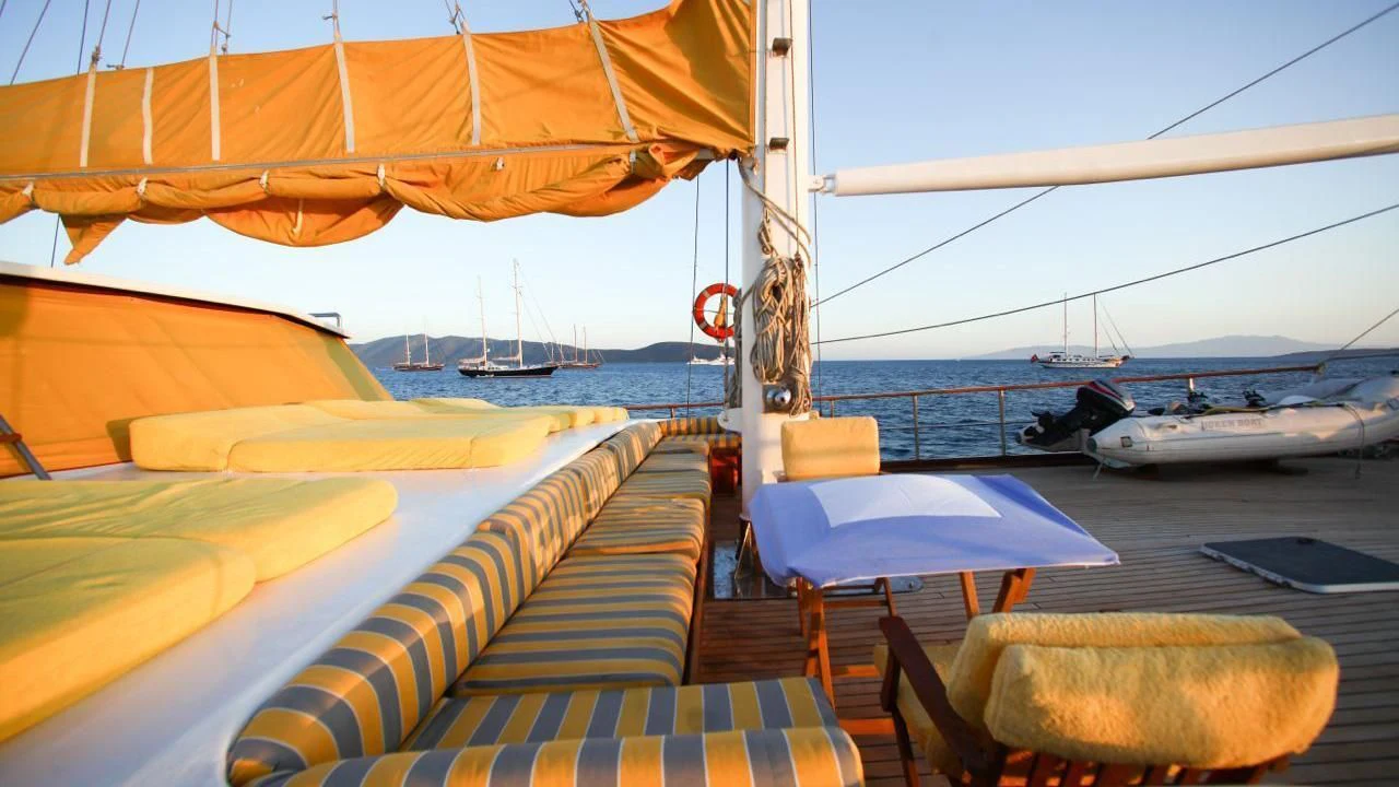 a deck with a table and chairs on it aboard WHITE SWAN Yacht for Sale