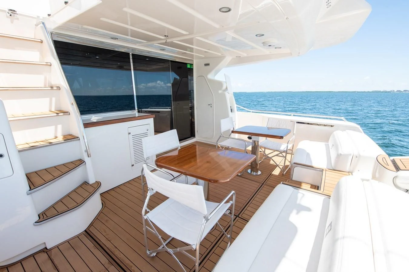 a room with a table chairs and a view of the ocean aboard HOPE Yacht for Sale
