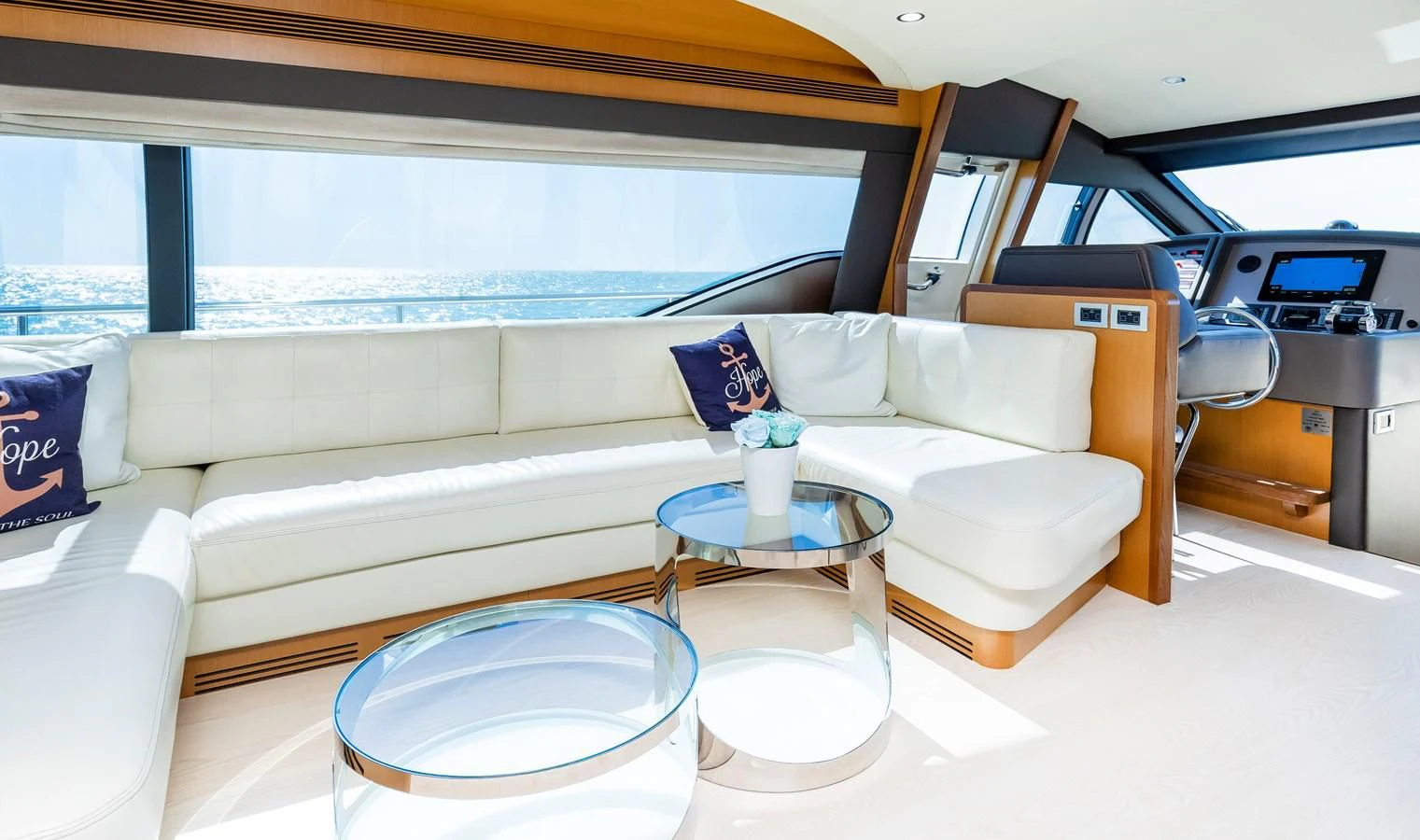 a white couch with a table and chairs in a room with a window aboard HOPE Yacht for Sale