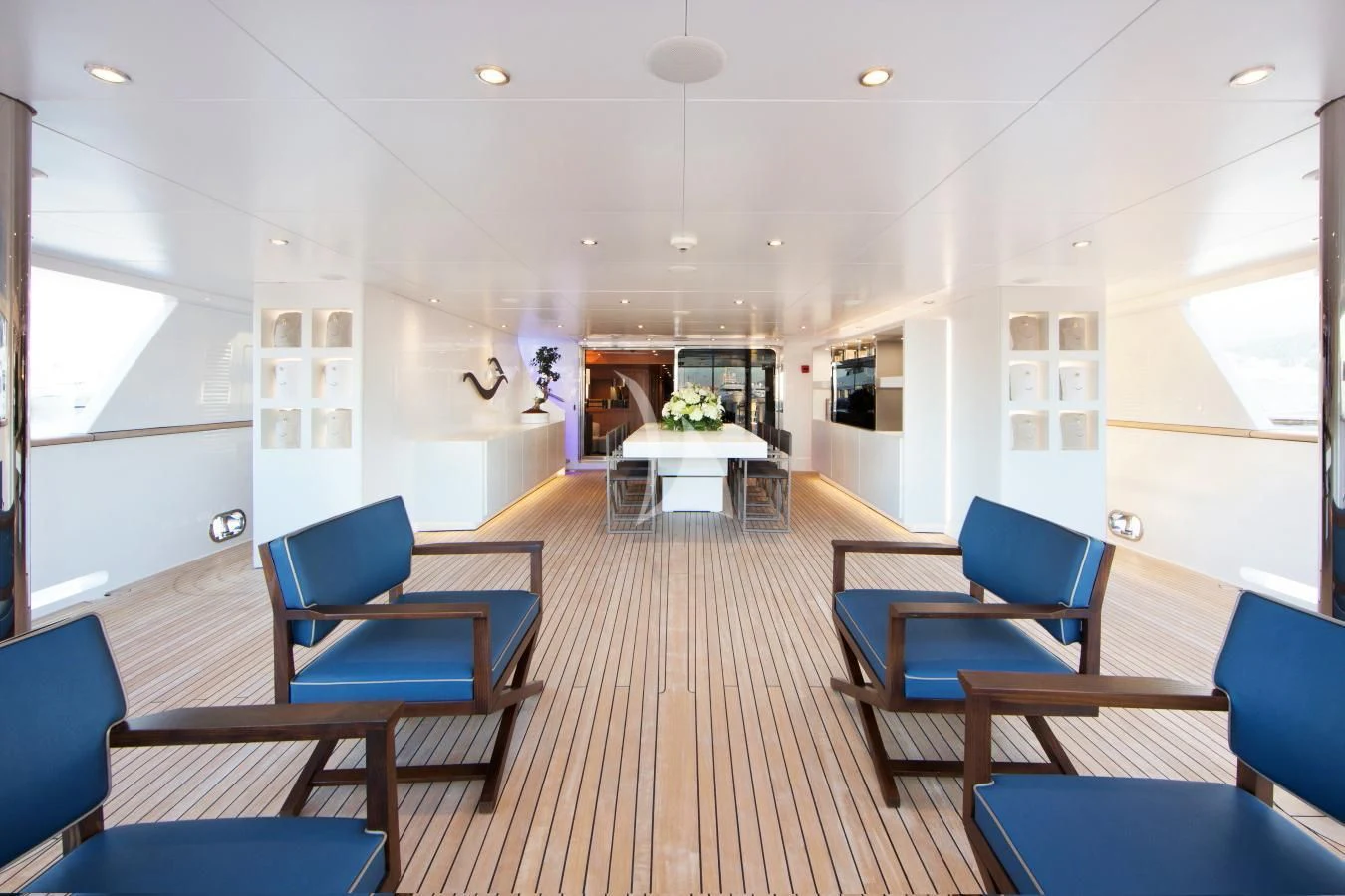 a long wooden hall with blue chairs aboard BEATRIX Yacht for Sale