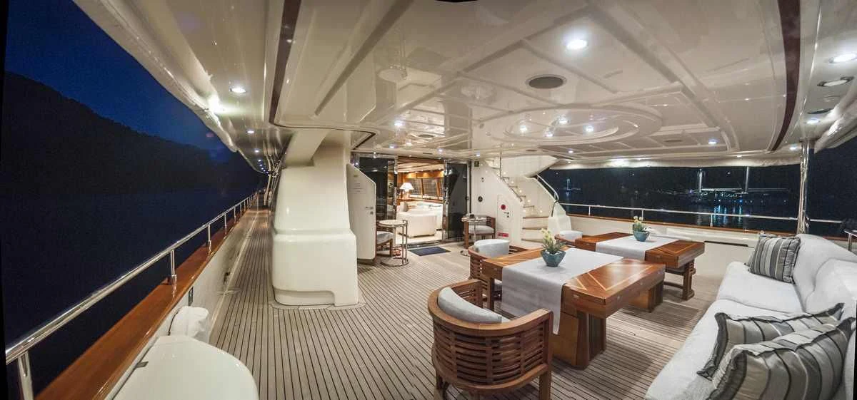 a large room with a table and couches aboard ARIELA Yacht for Sale