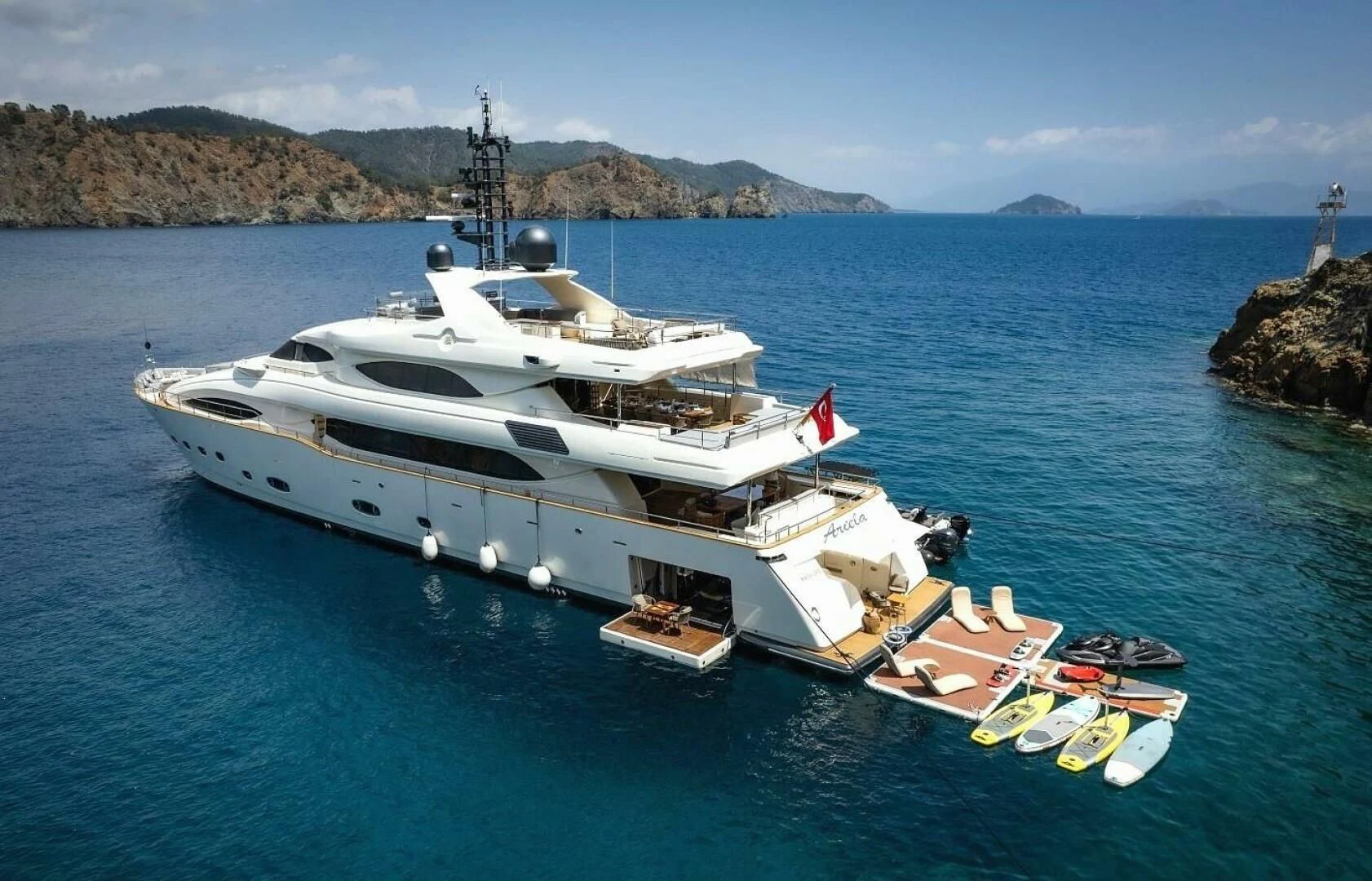 a boat with a dock and a boat on the water aboard ARIELA Yacht for Sale