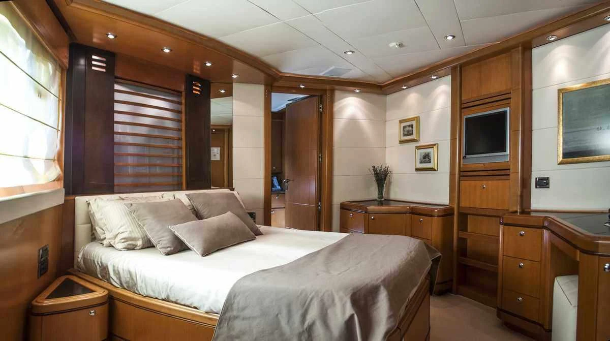 a bedroom with a bed and a television aboard ARIELA Yacht for Sale