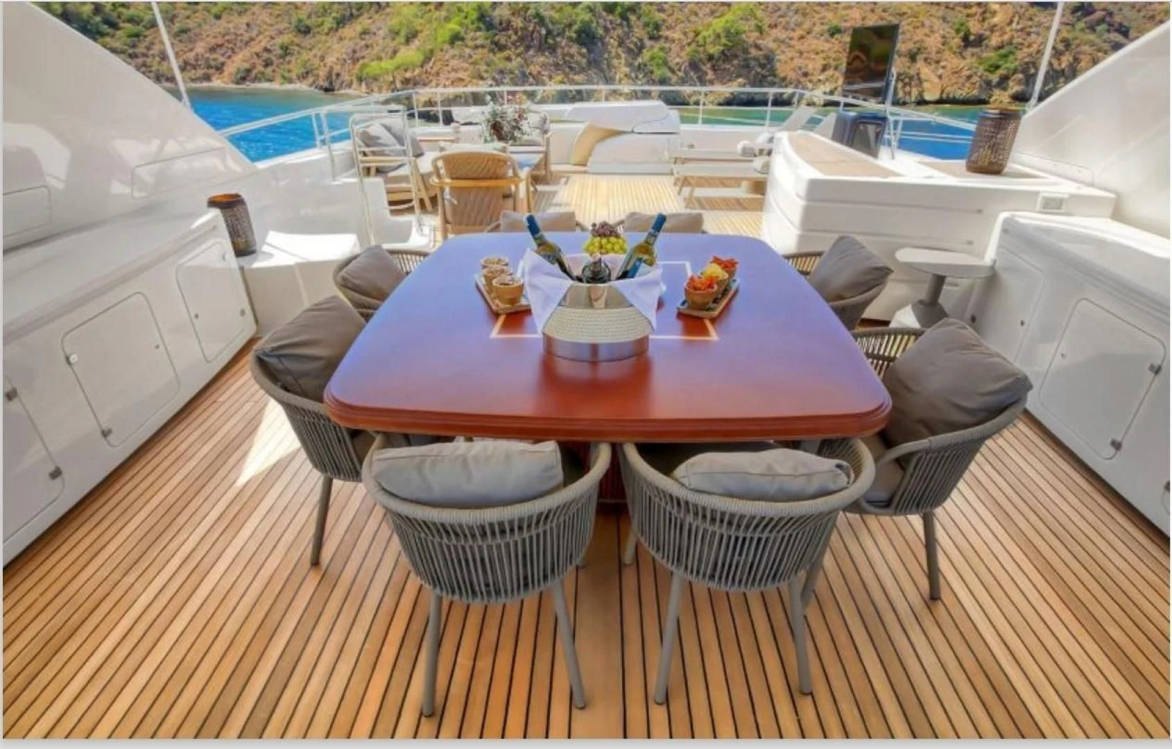 a table set with chairs and a pool in the background aboard ARIELA Yacht for Sale