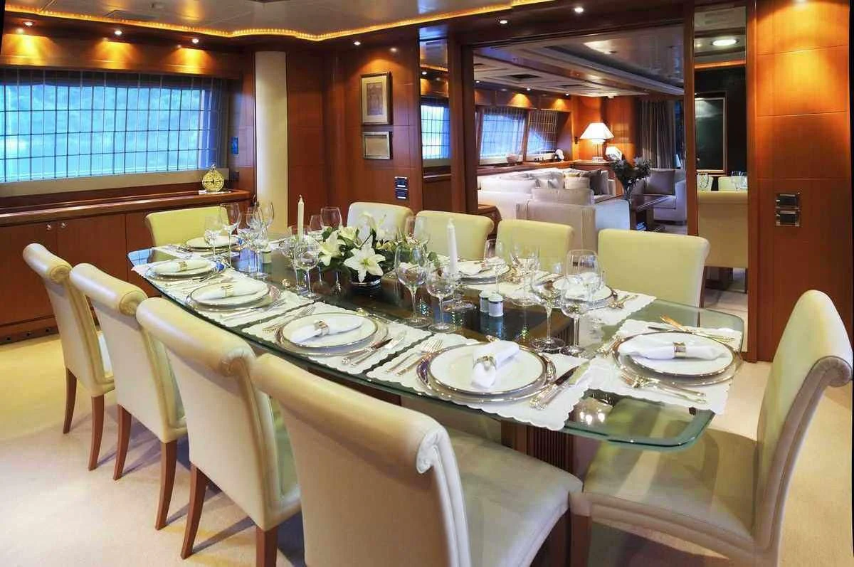 a dining room with white tables and chairs aboard ARIELA Yacht for Sale