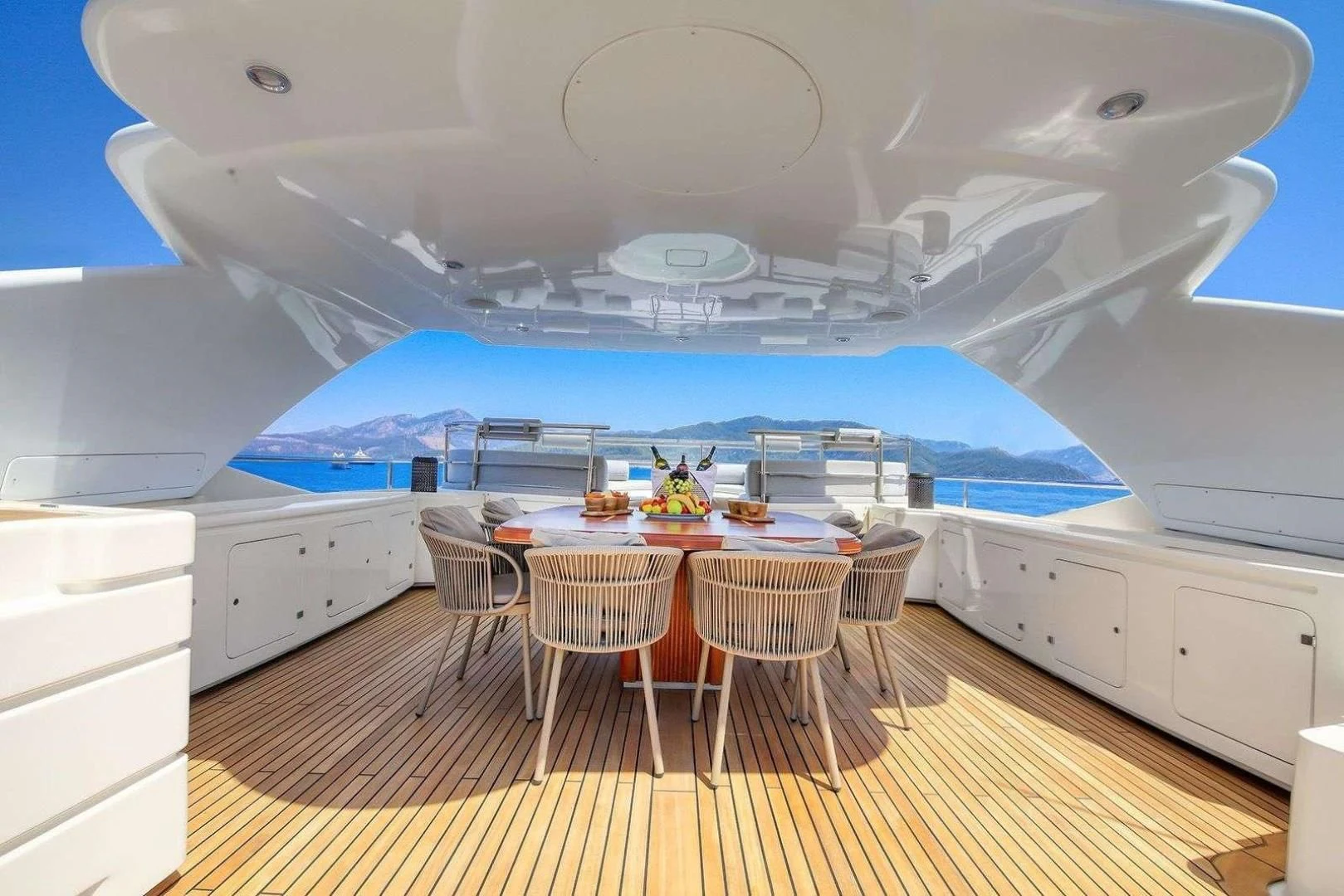 a large white boat with a table and chairs on a deck aboard ARIELA Yacht for Sale