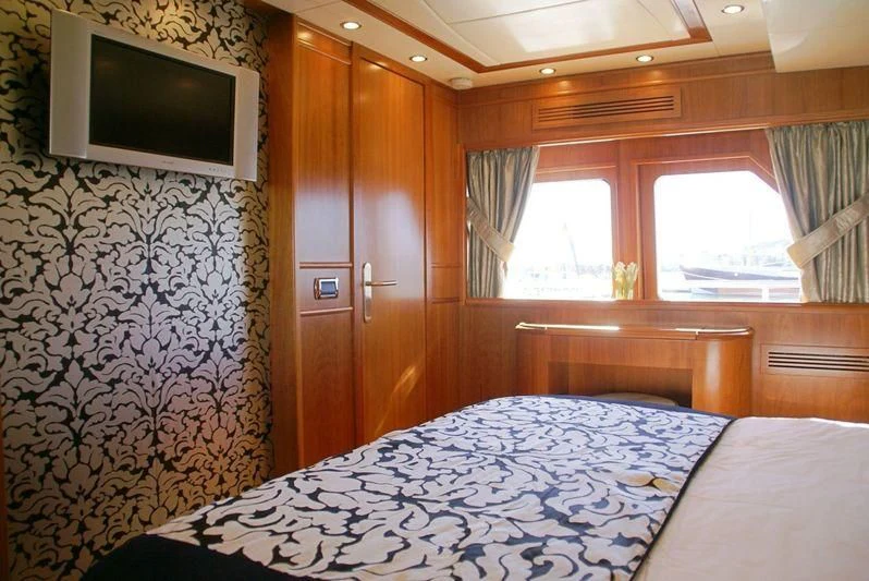 a bedroom with a bed and a television aboard AMANZI Yacht for Sale