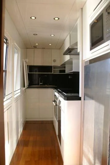 a kitchen with white cabinets aboard AMANZI Yacht for Sale