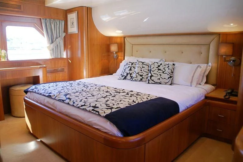 a bed with blue sheets aboard AMANZI Yacht for Sale