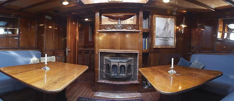a room with a fireplace and a table with candles on it aboard EILEEN II Yacht for Sale