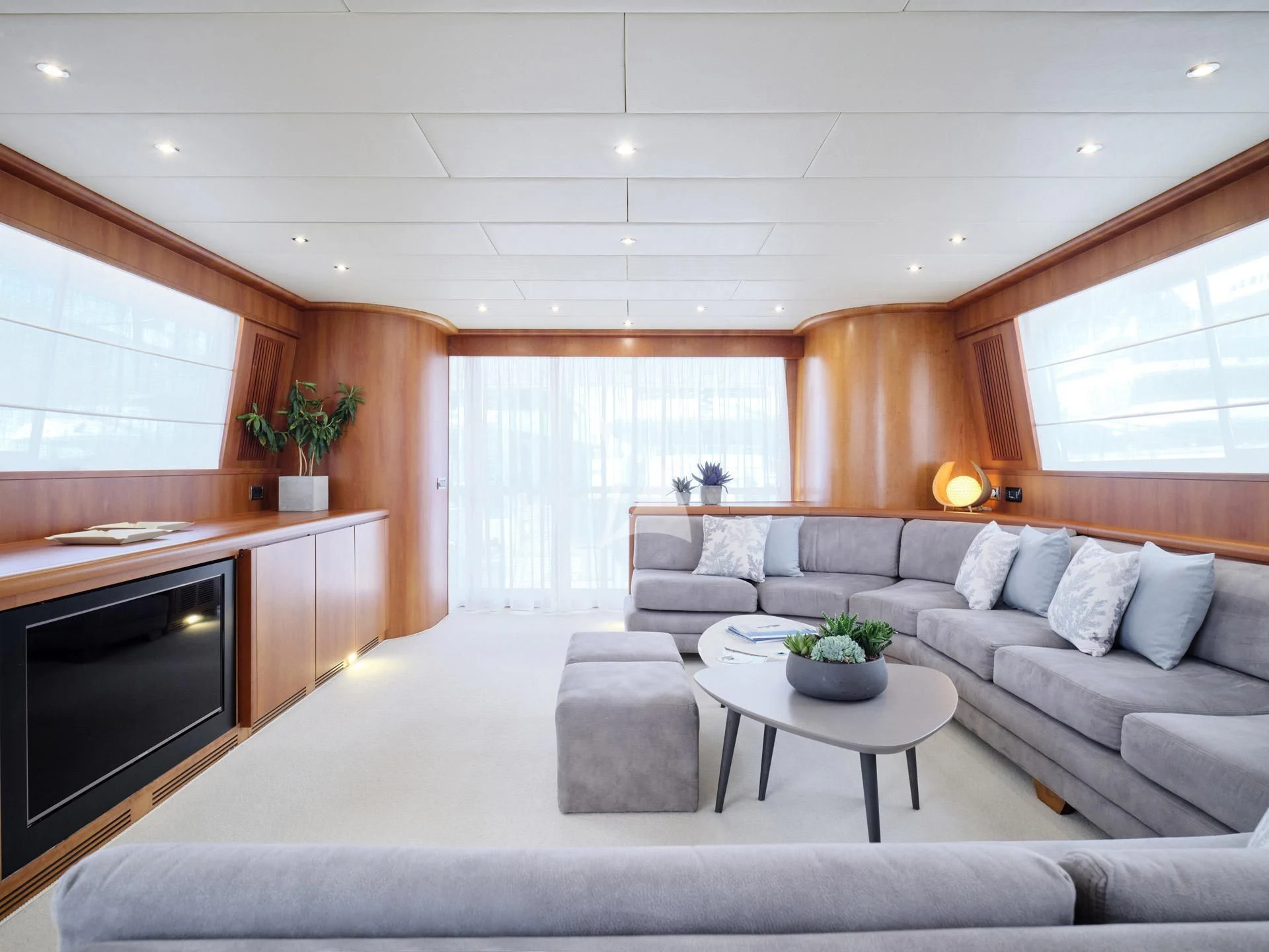 a living room with a white couch and a television aboard MANTRA Yacht for Sale