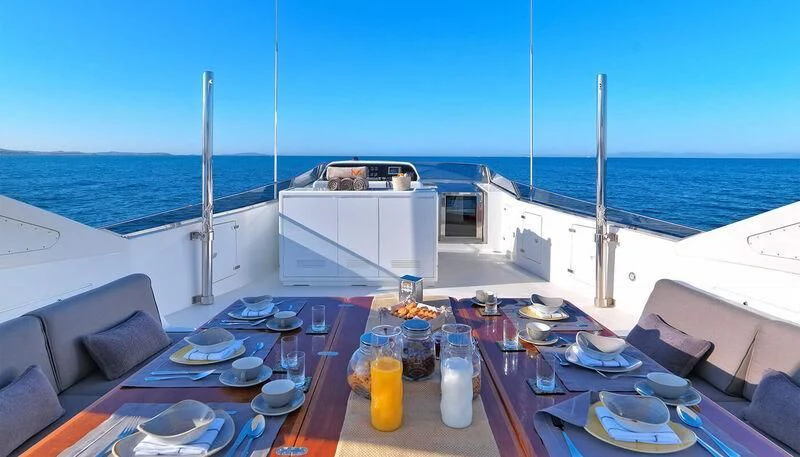 a table with plates and food on it on a boat aboard MANTRA Yacht for Sale