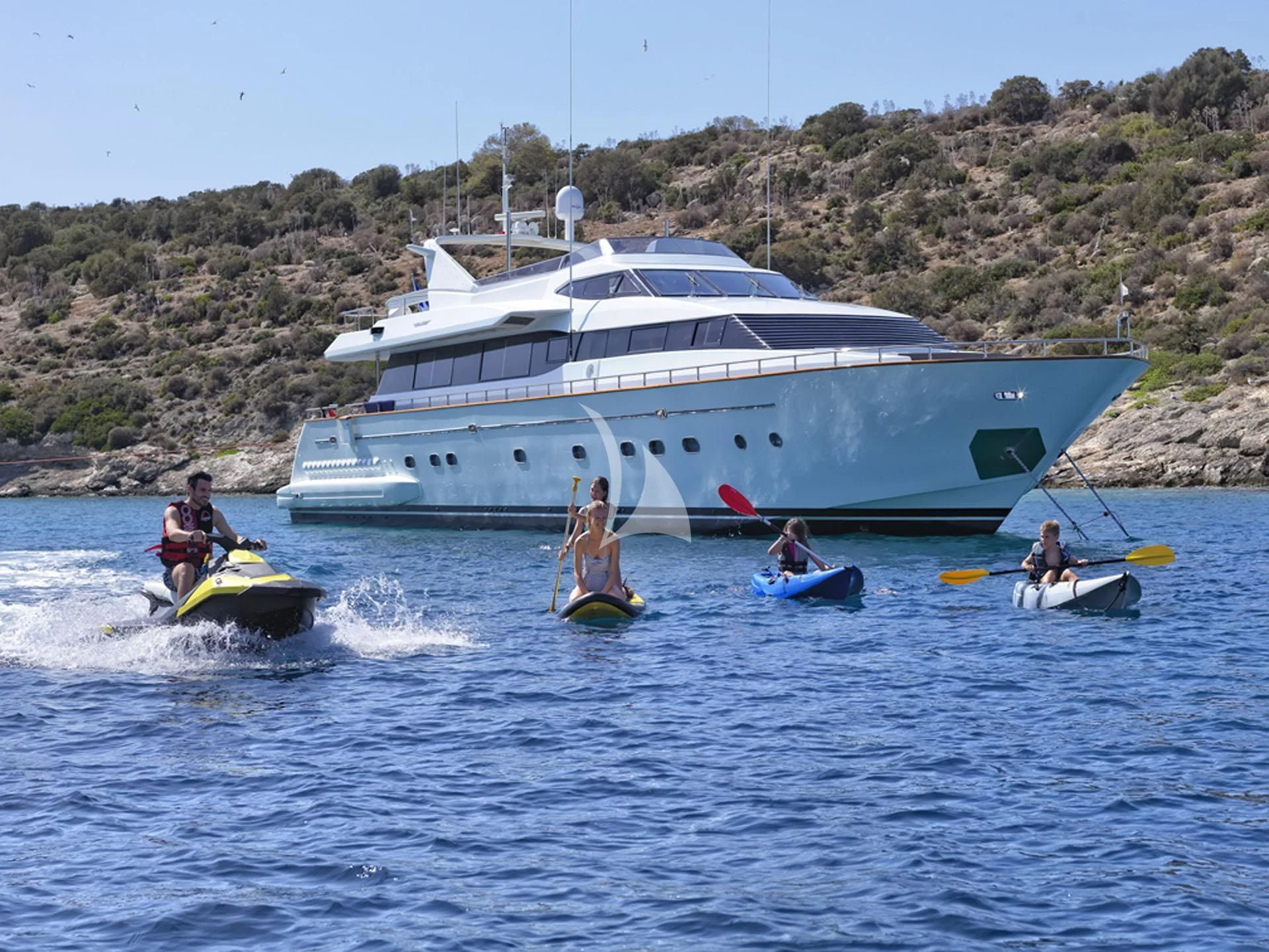 a group of people on kayaks in front of a boat aboard MANTRA Yacht for Sale
