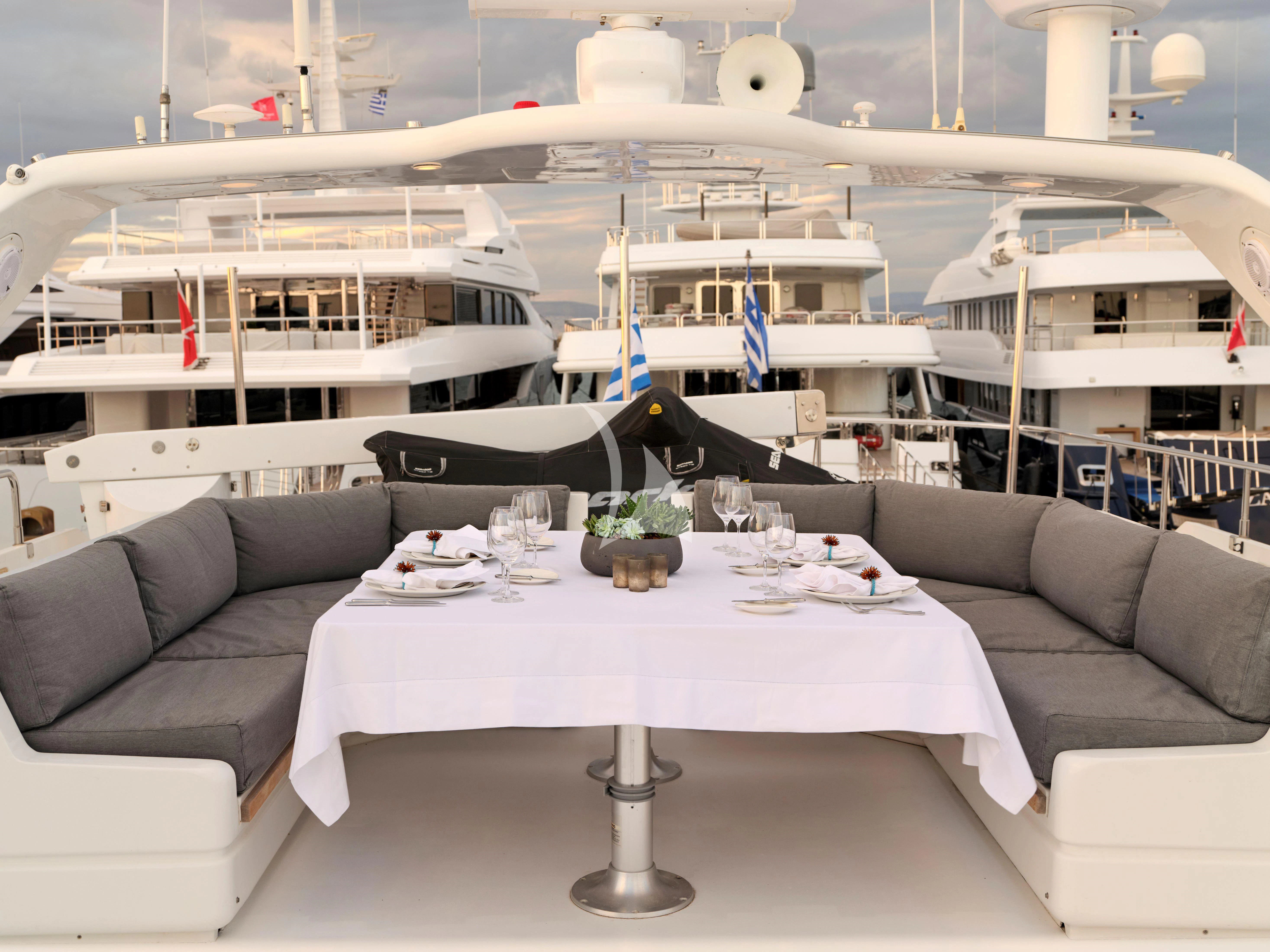 a white table with a white table and a white table with green plants on it aboard MANTRA Yacht for Sale