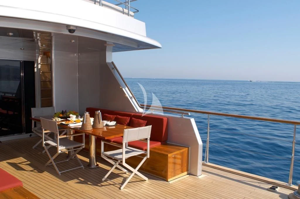 a deck with a table and chairs on it aboard TEMPEST WS Yacht for Charter