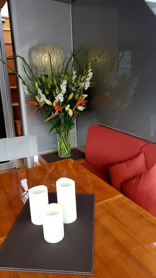 a vase with white flowers on a table aboard TEMPEST WS Yacht for Charter