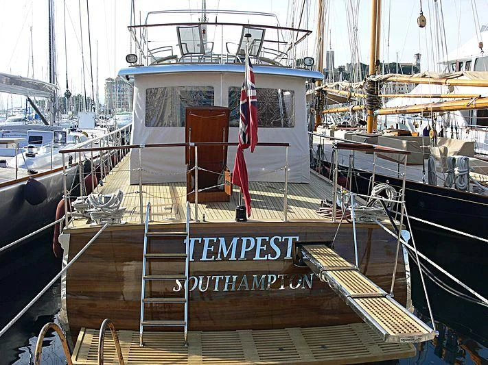 a boat with a flag on the deck aboard TEMPEST WS Yacht for Charter