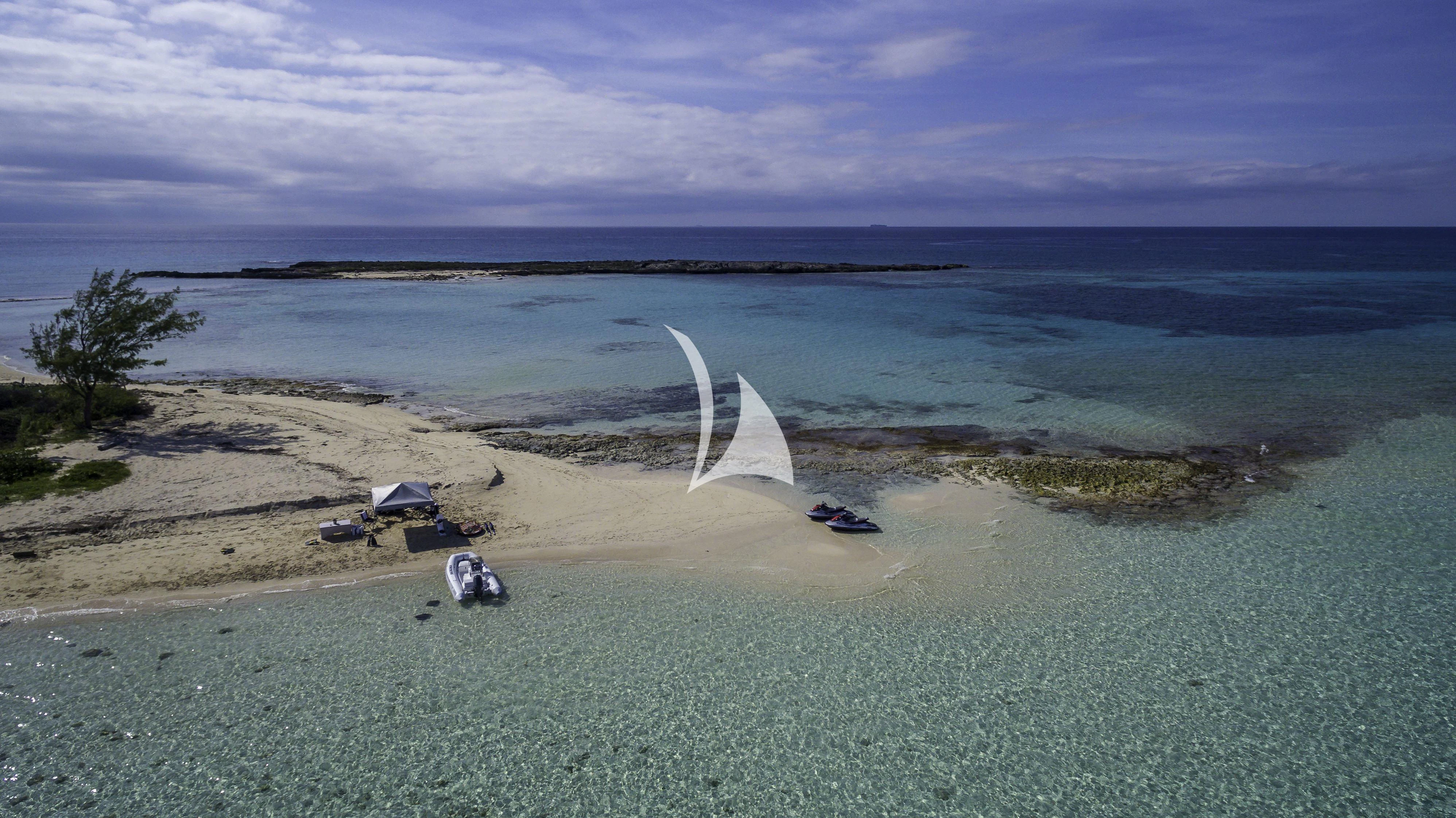 a white sailboat on a beach aboard AVALON Yacht for Sale