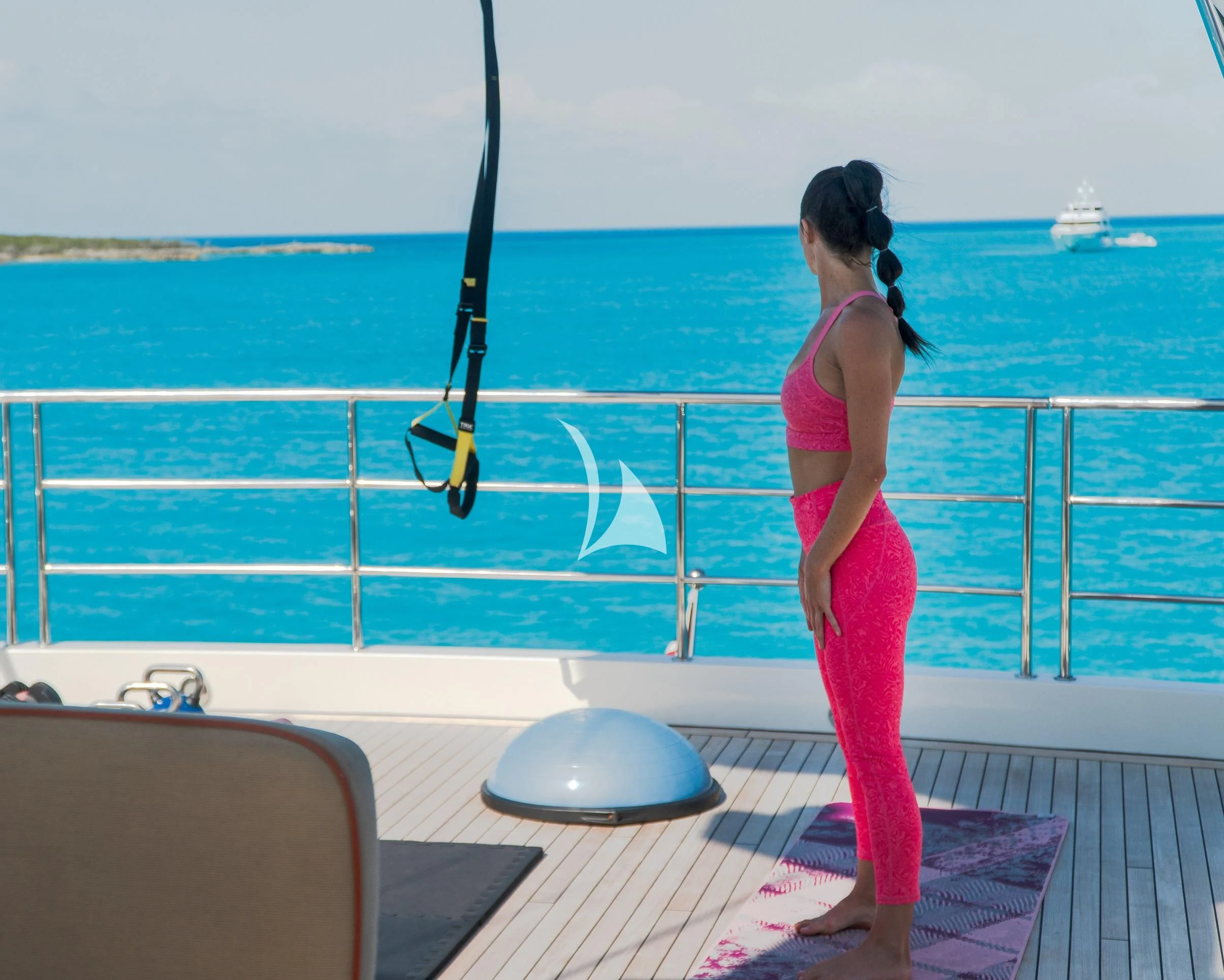 a woman standing on a deck near a pool aboard AVALON Yacht for Sale