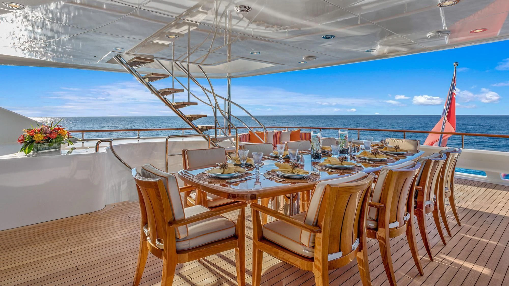 a table set for a meal on a deck overlooking the ocean aboard AVALON Yacht for Sale